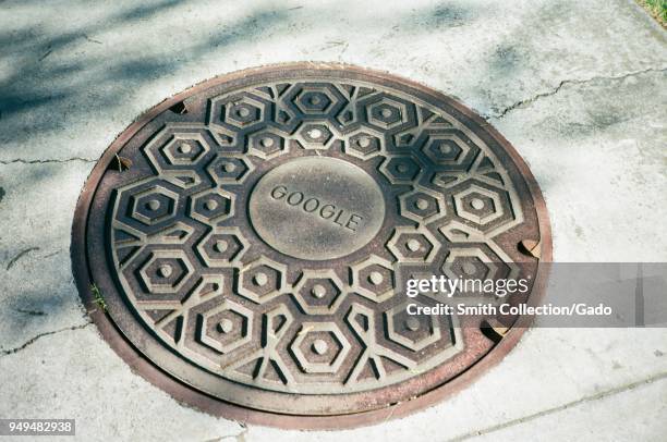 Google logo cast into a manhole utility cover, possibly a component of the Google Fiber fiber optic network, at the Googleplex, the Silicon Valley...