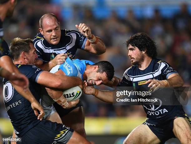 Michael Gordon of the Titans is wrapped up by the Cowboys defence during the round seven NRL match between the North Queensland Cowboys and the Gold...
