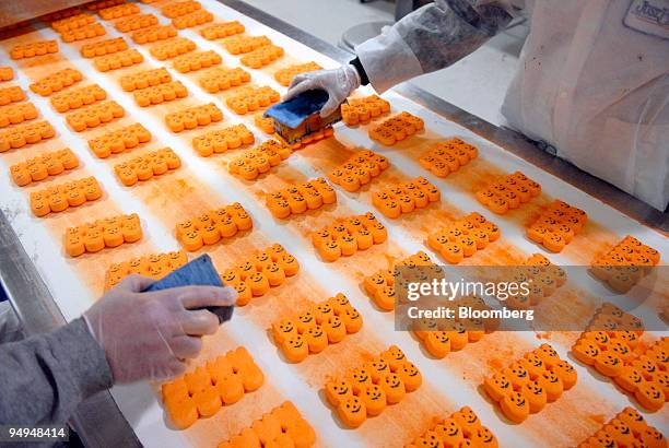 Workers put face stamps on Marshmallow candy Peeps pumpkins inside the Just Born Inc. Manufacturing facility in Bethlehem, Pennsylvania, U.S., on...