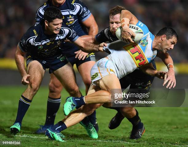 Michael Gordon of the Titans is tackled by Gavin Cooper and Lachlan Coote of the Cowboys during the round seven NRL match between the North...
