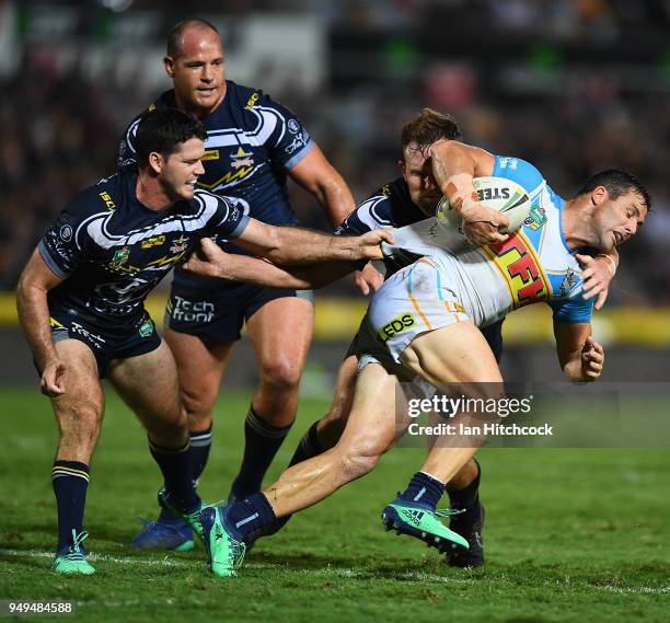 Michael Gordon of the Titans is tackled by Gavin Cooper and Lachlan Coote of the Cowboys during the round seven NRL match between the North...