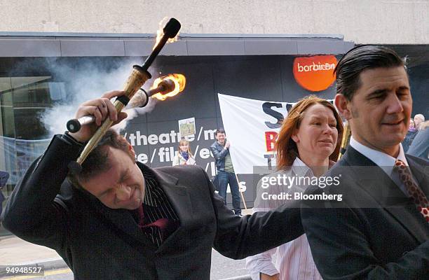 An anti-Royal Dutch Shell demonstrator accidentally sets fire to his hair outside the Barbican Center, in London, U.K., on Tuesday, May 19, 2009. The...