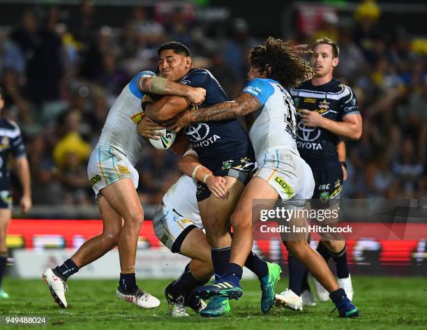 Jason Taumalolo of the Cowboys is wrapped up by the Titans defence during the round seven NRL match between the North Queensland Cowboys and the Gold...