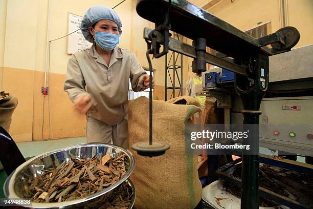 An employee of Pacific Basin Partnership Inc. Weighs out cinnamon bark at a processing plant in Hanoi, Vietnam, on Tuesday, Feb. 25, 2009. Cassia...