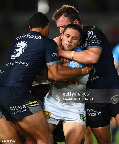 Michael Gordon of the Titans is tackled by Justin O'Neil and Gavin Cooper of the Cowboys during the round seven NRL match between the North...