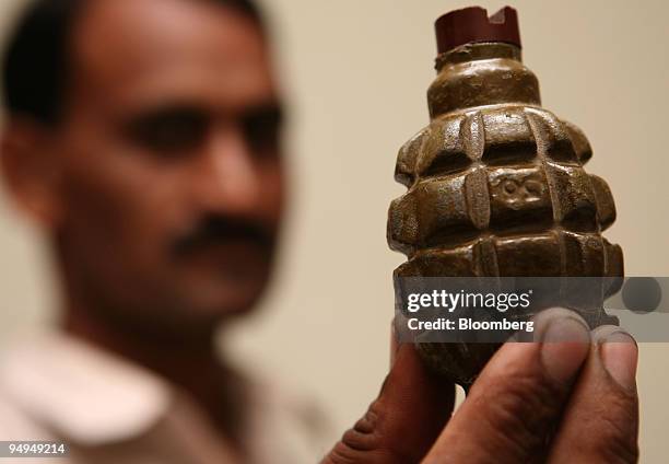 Mazhar Iqbal Mashwani, senior superintendent police/counter-terrorism, displays a hand grenade recovered from a suspect at the CID office in Karachi,...