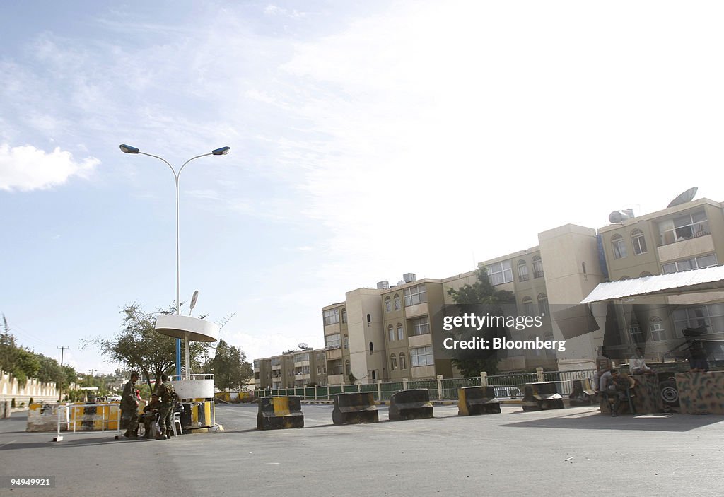 Yemeni policemen stand guard at a roadblock outside the U.S.