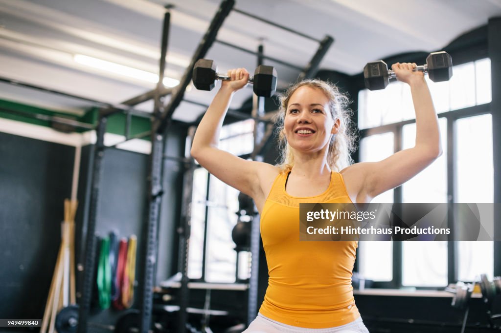Young Woman Doing Dumbbell Exercises