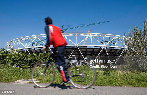 Cyclist rides past the main stadium for the 2012 Olympic Games in east London, U.K., on Wednesday, April 29, 2009. The London 2012 Olympic Park in...