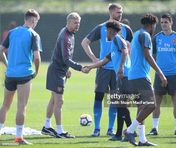 Arsenal manager Arsene Wenger shakes hands with Reiss Nelson before a training session at London Colney on April 21, 2018 in St Albans, England.