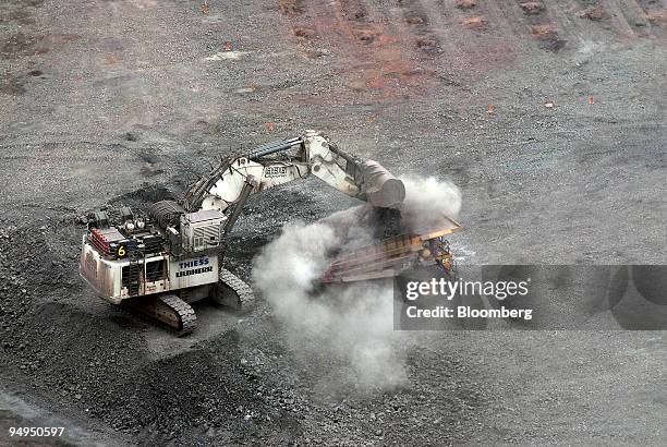 Bulldozer dumps a load of copper deposit into an earth mover at the base of an open pit mine at the OZ Minerals Ltd. Prominent Hill mine in South...