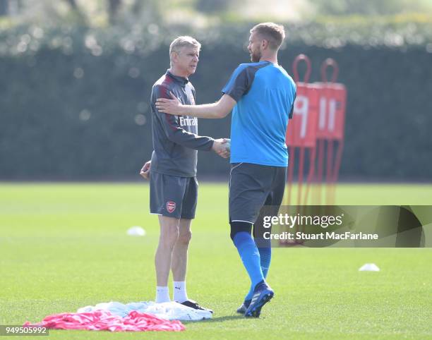 Arsenal manager Arsene Wenger shakes hands with Per Mertesacker before a training session at London Colney on April 21, 2018 in St Albans, England.