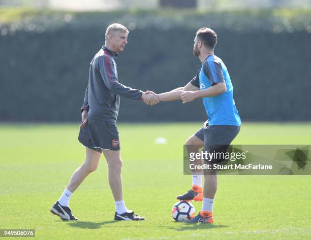 Arsenal manager Arsene Wenger shakes hands with Shkodran Mustafi before a training session at London Colney on April 21, 2018 in St Albans, England.