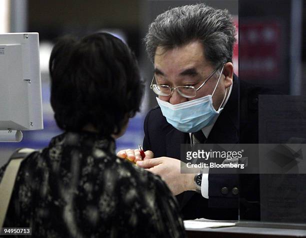 Quarantine officer wearing a surgical mask checks a passenger at Narita International Airport in Narita City, Chiba Prefecture, Japan, on Thursday,...