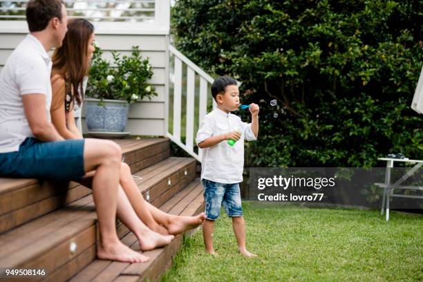 young family blowing bubbles at home outside - summer of 77 stock pictures, royalty-free photos & images
