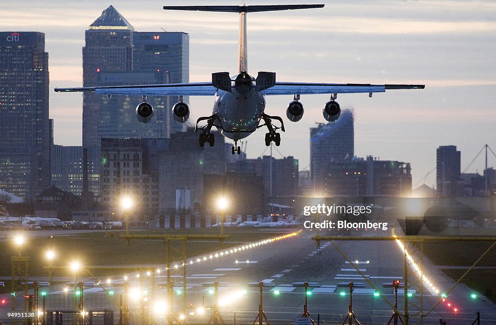 An airplane lands at London City airport with Canary Wharf i