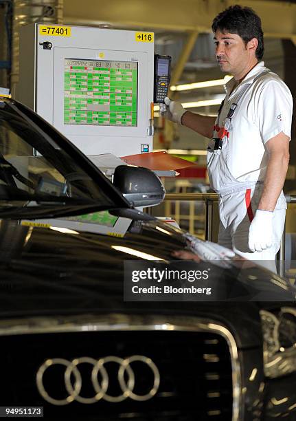 An Audi AG employee performs a final check on an Audi A4 automobile on the assembly line at the company's factory in Neckarsulm, Germany, on...