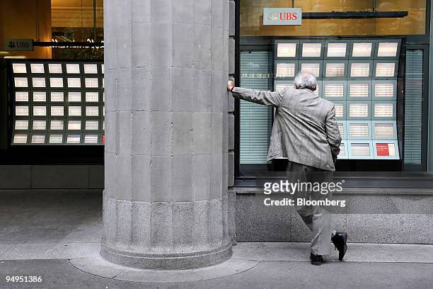 Pedestrian looks at stock tickers in a window at the UBS AG headquarters on Paradeplatz in Zurich, Switzerland, on Friday, May 1, 2009. UBS AG, the...