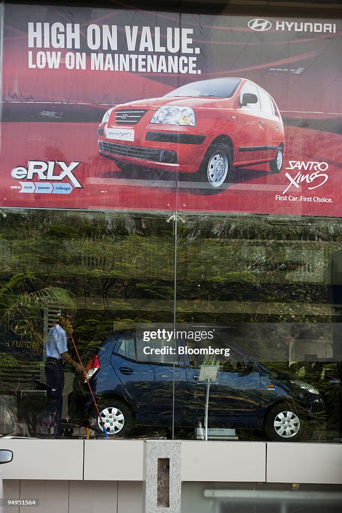 A janitor sweeps inside a Hyundai Motor Co. showroom in Mumb