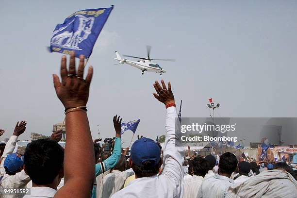Supporters of Mayawati, the chief minister of the Indian state Uttar Pradesh and Bahujan Samaj Party president, wave at the helicopter transporting...