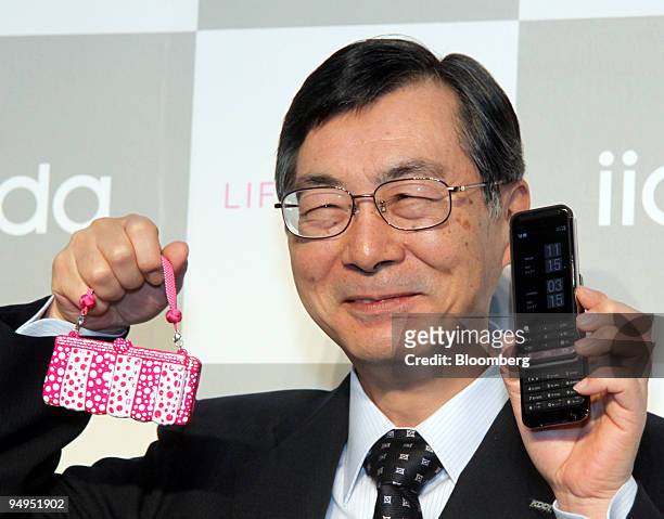 Tadashi Onodera, chairman and president of KDDI Corp., displays the company's new "iida" mobile phone during a news conference in Tokyo, Japan, on...