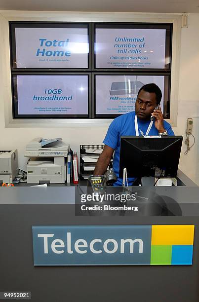 An employee works behind the counter prior to the opening of a Telecom Corp. Of New Zealand Ltd. Store after the company launched XT, their new...