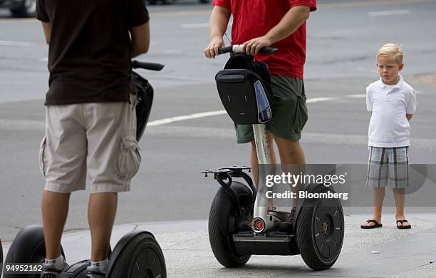 Boy looks at tour group riding Segway personal transporter vehicles in Washington, D.C., U.S., on Friday, Aug. 28, 2009. The Segway, which carries...