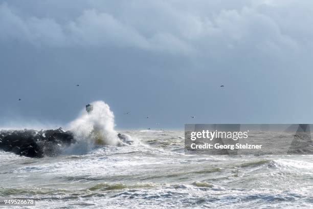 mole with spray in strong winds and waves, north sea, hvide sande, syddanmark, denmark - hvide sande denmark stock pictures, royalty-free photos & images
