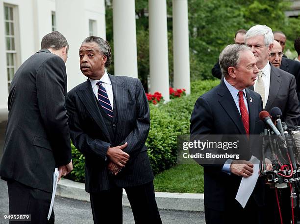 Arne Duncan, U.S. Secretary of education, left, whispers to Al Sharpton, a Democratic activist from New York, as Michael Bloomberg, mayor of New...