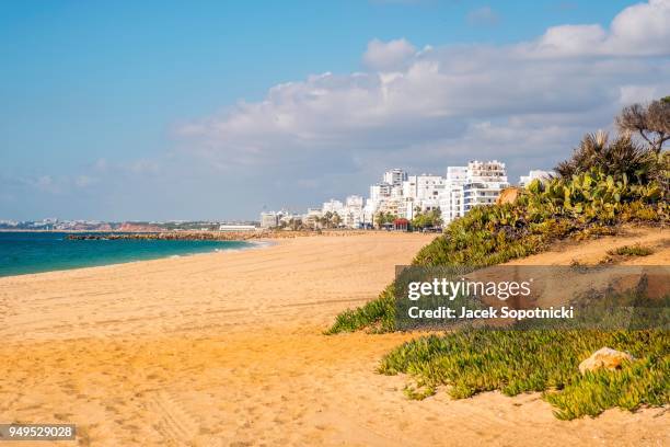 wide sand beach with apartement resorts, quarteira, algarve, portugal - apartement stockfoto's en -beelden