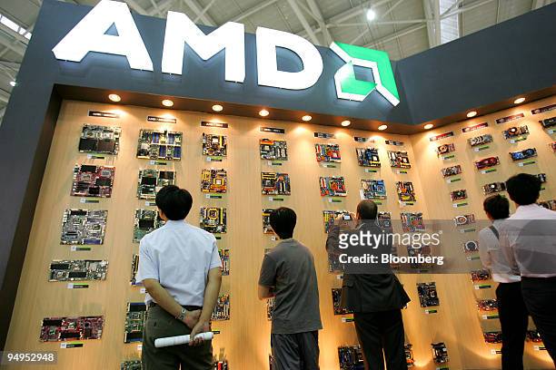 Visitors look at motherboards and chipsets at the AMD booth during the Computex Technology Expo in Taipei, Taiwan, on Tuesday, June 2009. Computex...