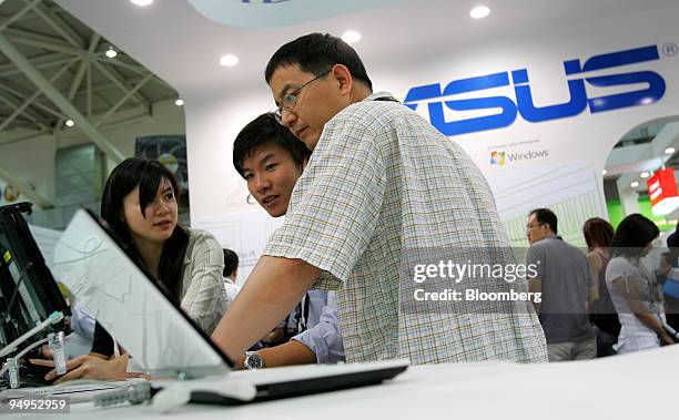 Visitors look at laptop computers at the Asustek Computer Inc. Booth during the Computex Technology Expo in Taipei, Taiwan, on Tuesday, June 2009....