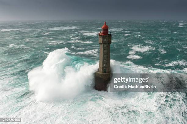 énorme vague au phare de la jument dans la tempête - leuchtturm sturm stock-fotos und bilder