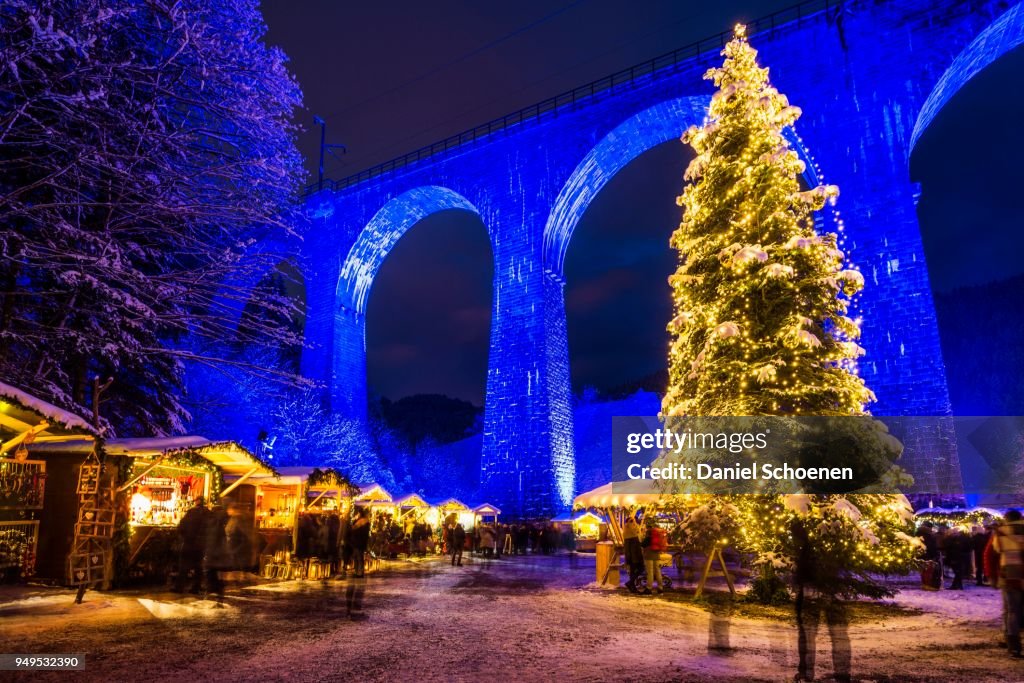 Snowy Christmas market under a railway viaduct, illuminated, Ravennaschlucht, Hoellental near Freiburg im Breisgau, Black Forest, Baden-Wuerttemberg, Germany