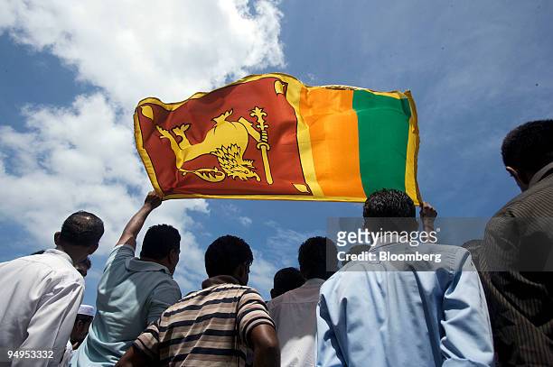 People hold up the Sri Lankan national flag at the National Victory Parade in Colombo, Sri Lanka, on Wednesday, June 3, 2009. Sri Lankan President...