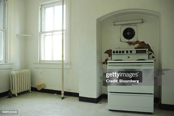 Plaster and paint hang from the walls of the kitchen area of a vacant officer's quarters on Governors Island in New York, U.S., on Saturday, Aug. 15,...