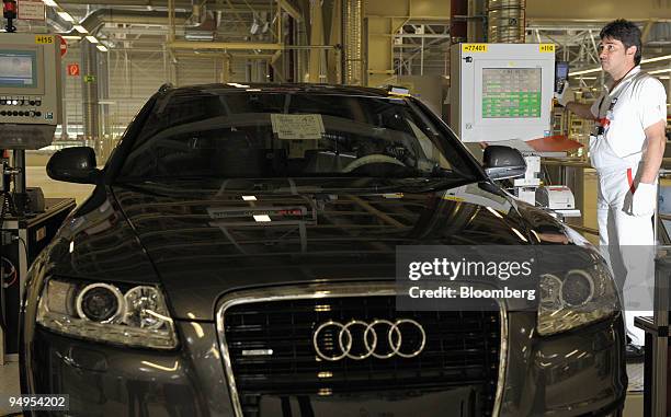 An Audi AG employee performs a final check on an Audi A4 automobile on the assembly line at the company's factory in Neckarsulm, Germany, on...