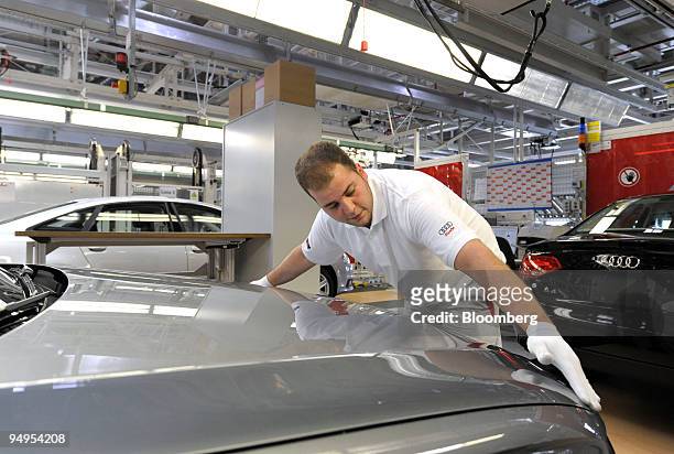 An Audi AG employee performs a final check on an Audi A4 automobile on the assembly line at the company's factory in Neckarsulm, Germany, on...