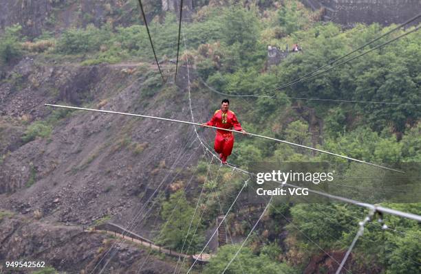 Chinese stuntman Saimaiti Aishan, seventh generation of the Dawazi, walks on the tightrope above a mining pit at Huangshi National Mine Park on April...