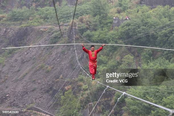 Chinese stuntman Saimaiti Aishan, seventh generation of the Dawazi, walks on the tightrope above a mining pit at Huangshi National Mine Park on April...