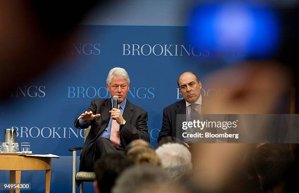 Muhtar Kent, chairman and chief executive officer of The Coca-Cola Co., right, listens to Former U.S. President Bill Clinton speak during a panel...