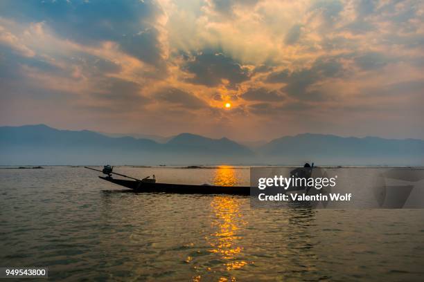 local intha fisherman rowing boats with one leg, unique local practice, sunrise, dawn, inle lake, inle lake, shan state, myanmar - intha fisherman stock pictures, royalty-free photos & images