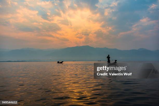 local intha fisherman rowing boats, sunrise, dawn, inle lake, shan state, myanmar - intha fisherman stock pictures, royalty-free photos & images