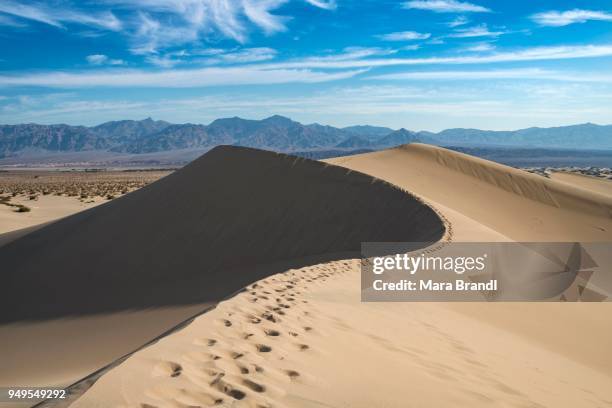 mesquite flat sand dunes, sand dune tracks, amargosa mountain range foothills, death valley national park, california, usa - amargosa mountains stock-fotos und bilder