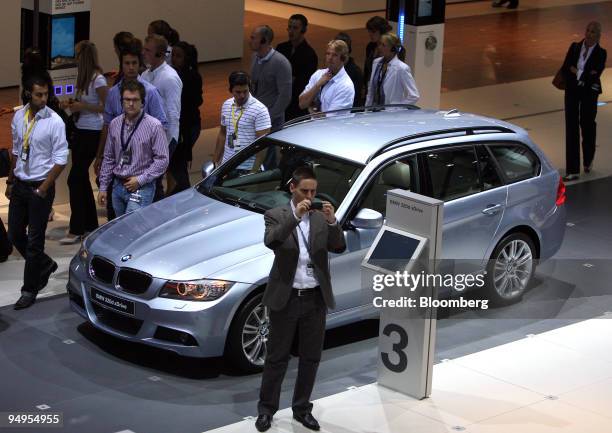 Visitors look at a BMW 320d xDrive automobile on display prior to the opening of the Frankfurt Motor Show, in Frankfurt, Germany, on Monday, Sept....