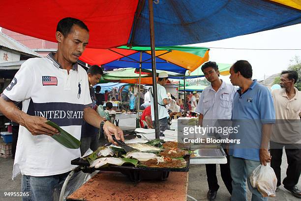 Mam Kamaruzaman sells grilled fish for the breaking of fast at a market near Kota Bharu in Kelantan, Malaysia, on Wednesday, Sept. 9, 2009. Growing...