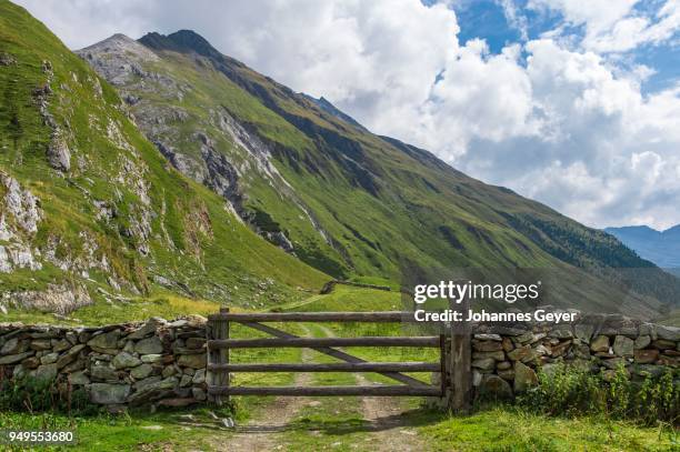 natural stone wall with wooden gates , mountain landscape, defereggen valley, high tauern national park, central eastern alps, east tyrol, austria - defereggen valley stock pictures, royalty-free photos & images