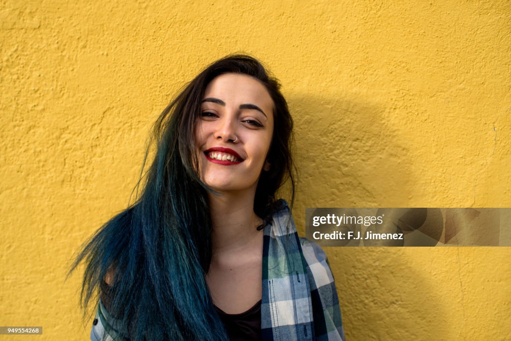 Portrait of young and beatiful girl in front of yellow wall