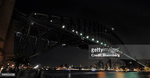 The Sydney Harbour Bridge, the Sydney Opera House and the city of Sydney are seen during Earth Hour in Sydney, Australia, on Saturday, March 28,...