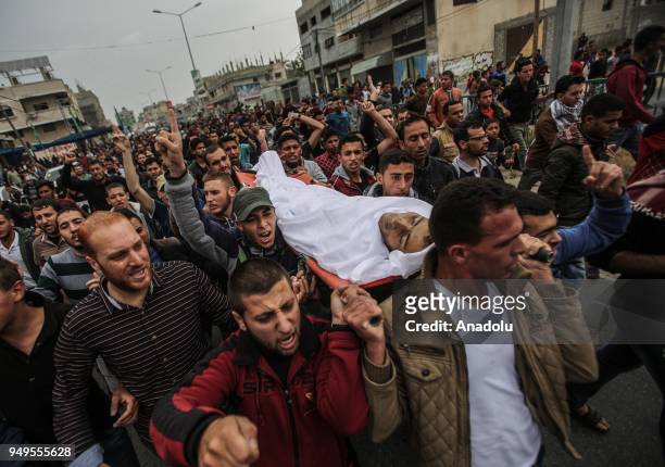 People carry the body of 29-year-old Saad Abdul Majid Abdul-Aal Abu Taha who shot dead by Israel forces during border rallies in Gaza, on April 21,...